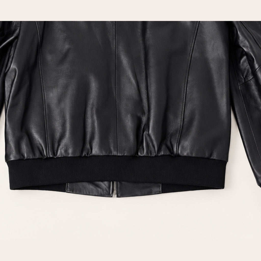 Black Bomber Jacket, ribbed hem and rear seam detail on an ivory studio background.