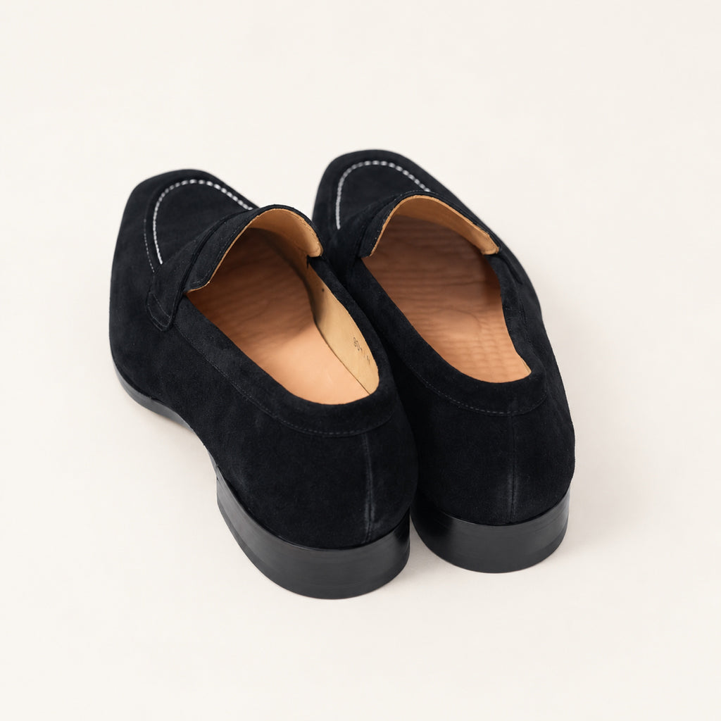 Black Suede Penny Loafers, rear view on an ivory studio background.