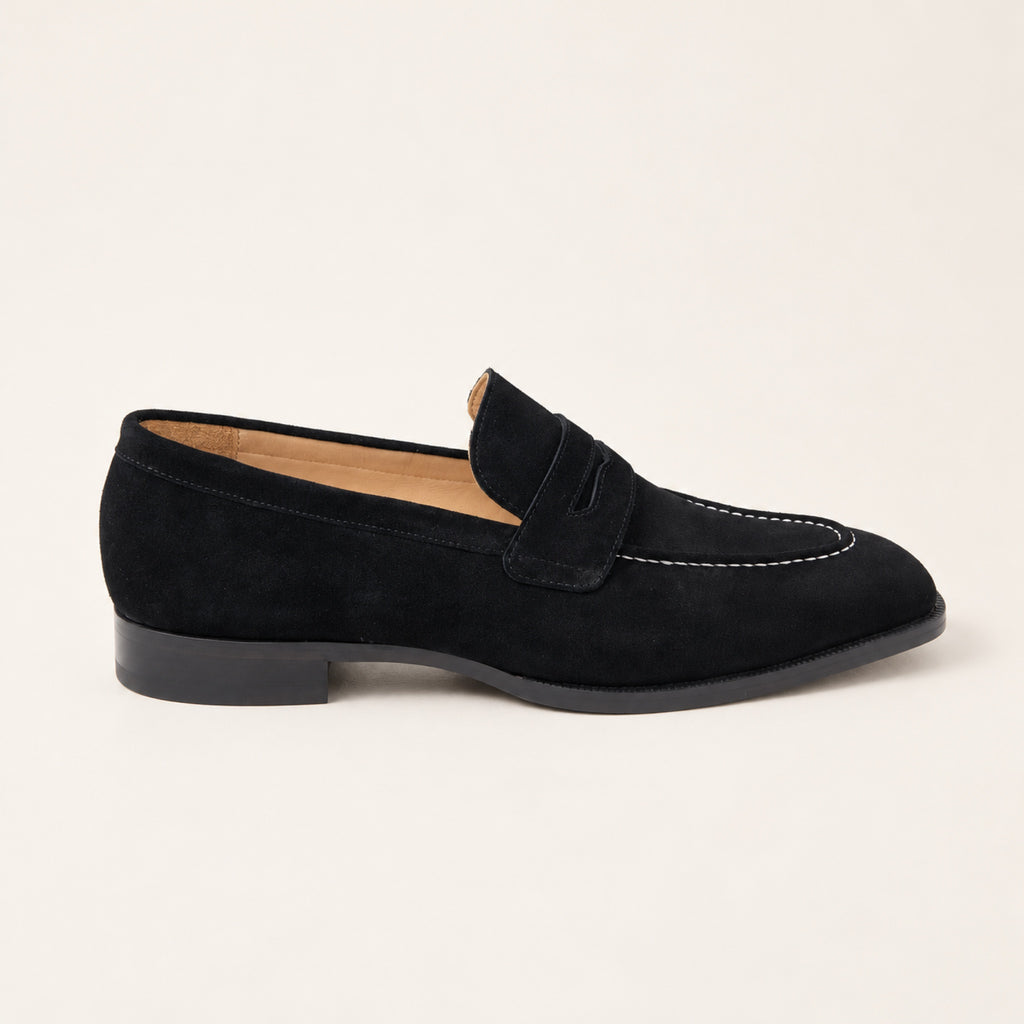Black Suede Penny Loafers, side profile on an ivory studio background.