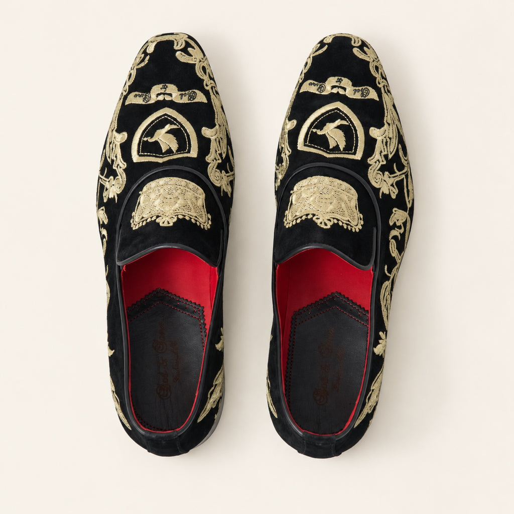 The Sultan Embroidered Loafer — Black & Gold, top view on an ivory studio background.